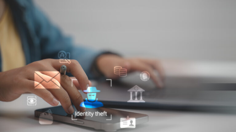 Close-up of a hand touching a smartphone with glowing holographic security icons, including 'Identity theft' text overlay