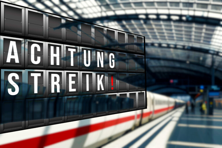 Airport departure board displaying the German warning 'ACHTUNG STREIK!'—indicating a strike impact at the airport